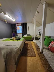 a bedroom with two beds and a table in it at Ainola Arctic Hillside in Rovaniemi
