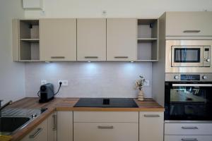 a kitchen with white cabinets and a counter top at Modernes voll möbliertes Apartment am See mit Garten, nahe BER in Bestensee +9 photos