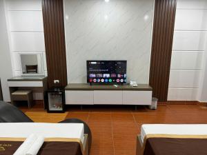 a room with two beds and a flat screen tv at NH Hotel in Hanoi