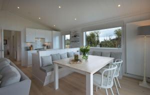 una cucina e un soggiorno con tavolo e sedie bianchi di Muir Lodge a Gatehouse of Fleet