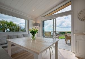una sala da pranzo con tavolo e vaso di fiori di Muir Lodge a Gatehouse of Fleet