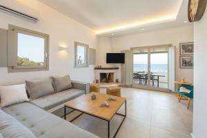 a living room with a couch and a table at Harma Blue Paros in Ambelas