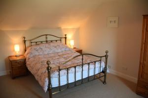 Un dormitorio con una cama y dos lámparas sobre mesas. en Munro Cottage, en Rockcliffe