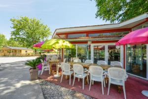 a restaurant with a table and chairs and umbrellas at Mobil-home Andernos Les Bains 4pers in Andernos-les-Bains