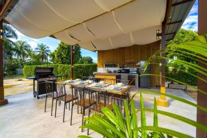 d'une terrasse avec une table, des chaises et un piano. dans l'établissement Fantastic 7 Bungalow Private Resort - BR7, à Ban Huai Sai Tai