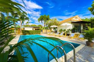 une piscine avec des chaises et une maison dans l'établissement Fantastic 7 Bungalow Private Resort - BR7, à Ban Huai Sai Tai