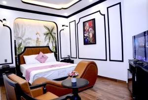 a bedroom with a bed and a table and a tv at New Pearl Hotel in Ho Chi Minh City