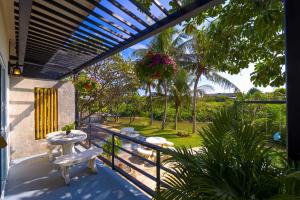 un patio avec une table et des bancs sur un balcon dans l'établissement Fantastic 7 Bungalow Private Resort - BR7, à Ban Huai Sai Tai