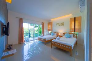 une chambre d'hôtel avec deux lits et un balcon dans l'établissement Fantastic 7 Bungalow Private Resort - BR7, à Ban Huai Sai Tai 92 autres photos