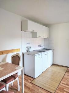 a small kitchen with white cabinets and a table at Ubytovaní Šaslun in Kolešov +57 photos
