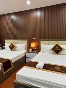 a hotel room with two beds and a lamp at NH Hotel in Hanoi +18 photos