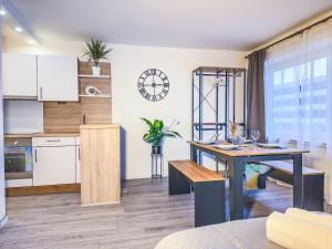 a kitchen with white cabinets and a wooden table at ImmoStay City Apartments - Modern & WiFi in Bremen