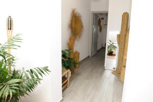 a hallway with potted plants and an open door at Calas De Meca in Los Caños de Meca