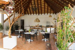 a restaurant with tables and chairs and a kitchen at Calas De Meca in Los Caños de Meca