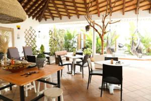 a restaurant with tables and chairs and plants at Calas De Meca in Los Caños de Meca