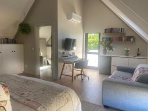 a bedroom with a bed and a desk with a computer at Endless Summer in St Francis Bay