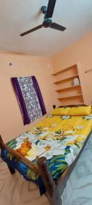 Un dormitorio con una cama con un edredón colorido. en Smiley HomeStay at Chidambaram, en Chidambaram