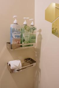 a bathroom with three bottles of soap and a dispenser at Minimalist Chic City Loft in Iloilo City