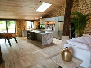 an open kitchen and living room with a large island at Domaine de Pertignas in Saint-Vincent-de-Pertignas