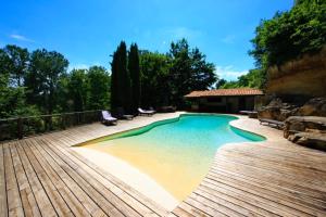 a swimming pool with chairs and a wooden deck at Domaine de Pertignas in Saint-Vincent-de-Pertignas