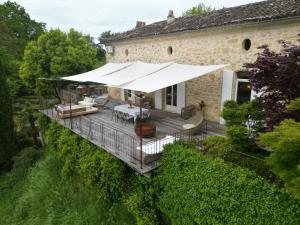 an outdoor deck with a large white umbrella at Domaine de Pertignas in Saint-Vincent-de-Pertignas