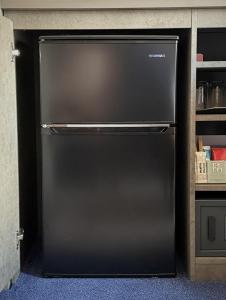 a black refrigerator in a kitchen next to a shelf at Hotel Keihan Universal Tower in Osaka