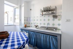 a small kitchen with a sink and a table at Lo Nardo Accommodation in Lipari