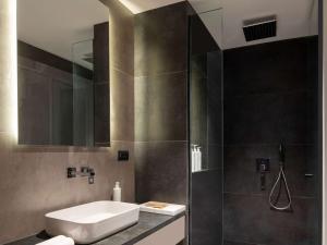 a bathroom with a sink and a shower at Swissôtel Resort Bodrum Beach in Turgutreis