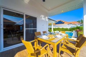 comedor con mesa amarilla y sillas en Brand-New Modern 3-Bedroom Villa - MB20, en Hua Hin