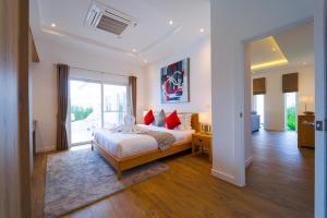 Un dormitorio con una cama con almohadas rojas. en Brand-New Modern 3-Bedroom Villa - MB20, en Hua Hin 77 fotos más