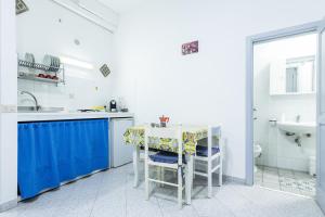 a white kitchen with a table and a sink at Lo Nardo Accommodation in Lipari +37 photos