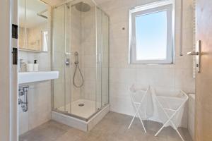 a bathroom with a glass shower and a sink at Flatista Homes - Maisach in Maisach