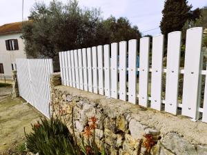 a white fence on top of a stone wall at Country House in Cunski
