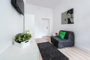 - un salon avec une chaise et un oreiller vert dans l'établissement Mieszkanie przy deptaku Sopot, à Sopot