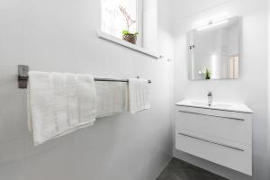 a white bathroom with a sink and a mirror at Mieszkanie przy deptaku Sopot in Sopot +13 photos