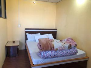 ein Schlafzimmer mit einem Bett mit weißen Laken und Kissen in der Unterkunft Hotel Mountain Nest in Nagarkot
