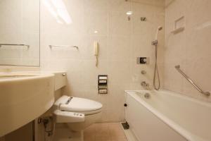a bathroom with a toilet and a tub and a sink at Hotel Keihan Universal Tower in Osaka