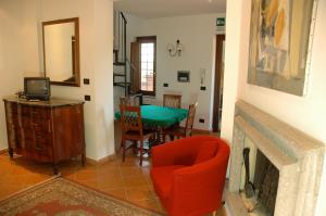 - un salon avec une chaise rouge et une cheminée dans l'établissement Villa Iris, à Corchiano