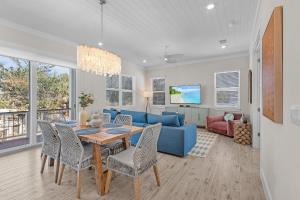 Una sala de estar con una mesa y un sofá azul. en 211 Blue Palm- Spacious 5-Bedroom Pool Home, Steps from Beach! home, en Fort Myers Beach