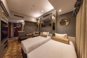a hotel room with two beds and a couch at Hotel Keihan Universal Tower in Osaka