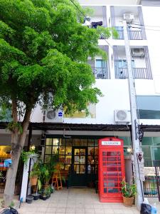 a red phone booth in front of a building at The London Tearoom in Chiang Mai