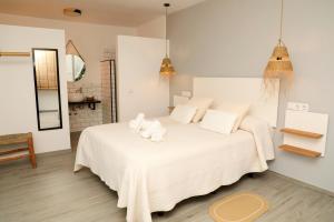 a bedroom with a white bed with towels on it at Calas De Meca in Los Caños de Meca