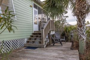 a house with a wooden porch with a chair on it at The Rookery III 5008 cottage in Gulf Shores