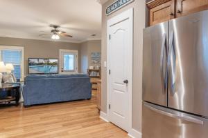 a kitchen with a stainless steel refrigerator in a living room at The Rookery III 5008 cottage in Gulf Shores +23 photos