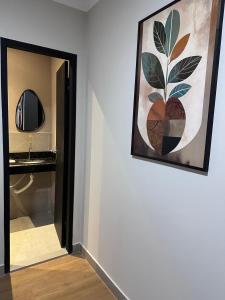 Ein Gemälde hängt an einer Wand neben einem Badezimmer in der Unterkunft Otto Hotel in Governador Valadares