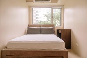 a bed in a small room with a window at Pool Garden Tranquility in Iloilo City