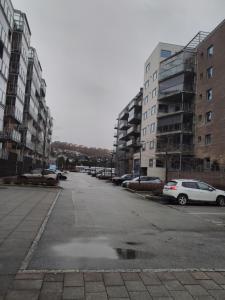 an empty parking lot with parked cars and buildings at Mulka Sandnes Room in Sandnes