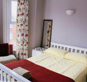 ボーンマスにあるCharminster Homestayのベッドと鏡と窓のある寝室
