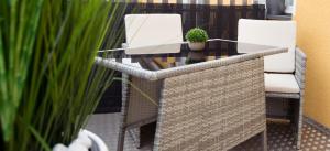 two white chairs and a table with a potted plant at FeWo 02 Maisonette im Carre`Charlott in Pulsnitz +1 photo
