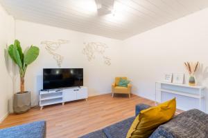 a living room with a couch and a flat screen tv at Monteurwohnung Dresden-Klotzsche I in Dresden